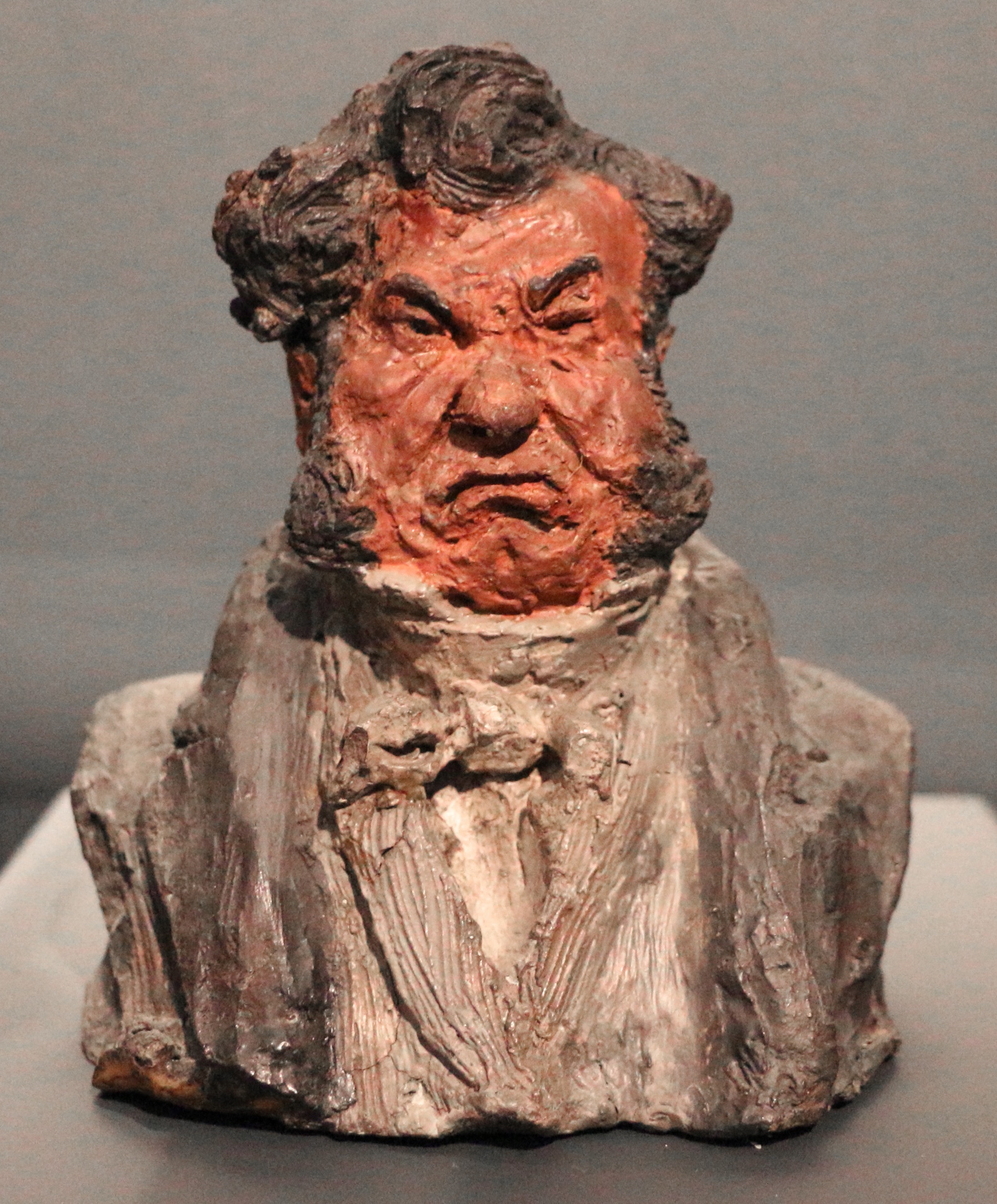 Terracotta bust sculpture by Honoré Daumier, showcasing a caricatured figure with an exaggerated expression.