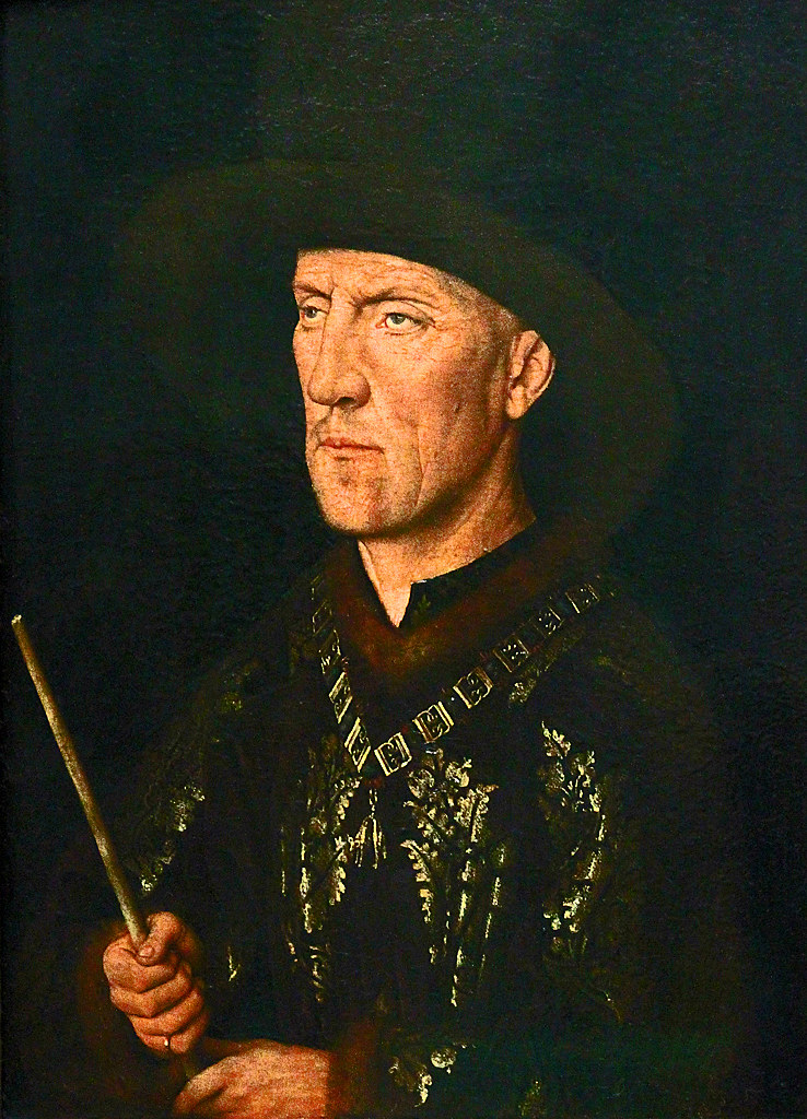 The image captures a portrait of Baudouin de Lannoy, a work attributed to Jan van Eyck, distinguished by the subject's solemn and introspective gaze. De Lannoy, a member of the Order of the Golden Fleece, is depicted wearing a dark robe with the order's emblem and a distinguished black chaperon hat, which was typical of the Burgundian court's fashion. His hand grips a staff, suggesting authority and stature. The artist’s expertise in realism is evident in the precise rendering of textures from the fine embroidery on the robe to the flesh tones of de Lannoy's face. This portrait exemplifies the Northern Renaissance's focus on individualism and the skillful portrayal of nobility.