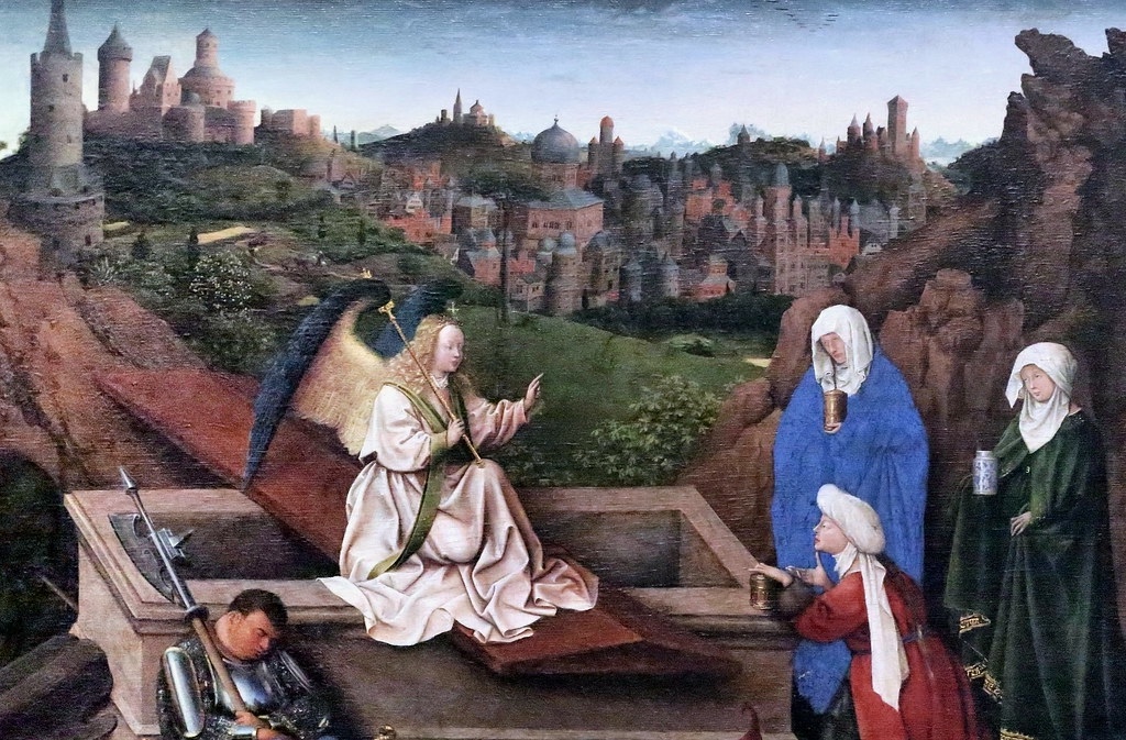 15th-century painting of a religious scene with the Virgin Mary and two saintly figures against the backdrop of a city resembling Bruges, showcasing the Northern Renaissance's intricate detail in landscape and character depiction.