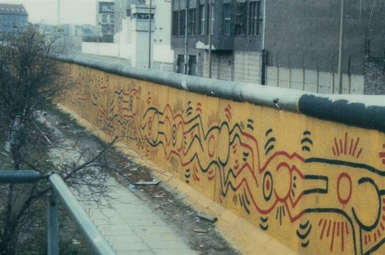 Berlin Mural (1986) by Keith Haring Artwork reflects themes of unity and freedom, painted on the Berlin Wall as a symbol of hope and change.