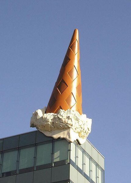 Dropped Cone (2001) reflects a massive, overturned ice cream cone atop the roof of the Neumarkt Galerie shopping mall
